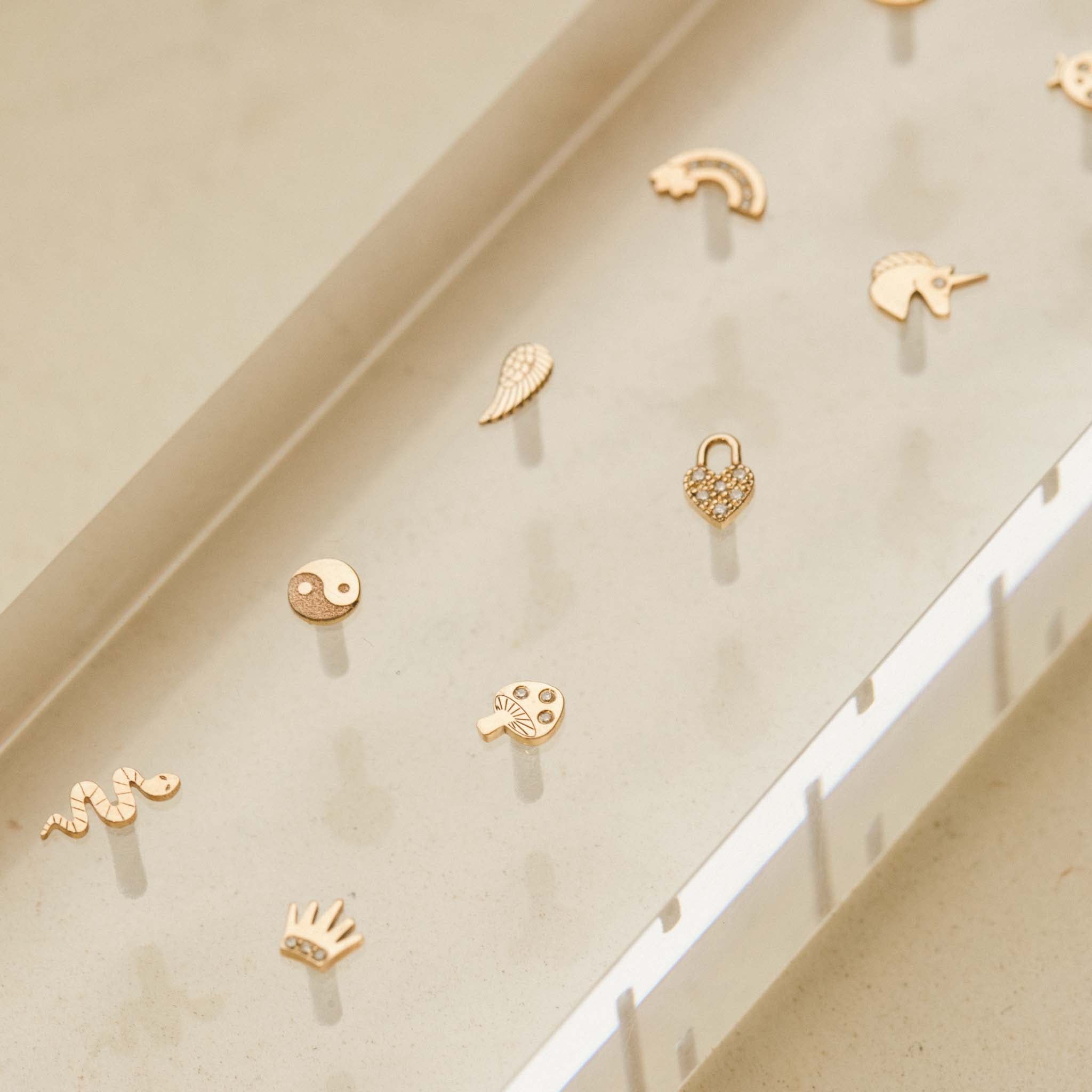 ZoÃ« Chicco 14k Gold Itty Bitty Diamond Mushroom Stud Earring in an acrylic tray with other itty bitty earring styles