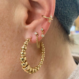close up of ear wearing Zoë Chicco 14kt Gold Graduated Rondelle Bead Medium Hoop Earring 