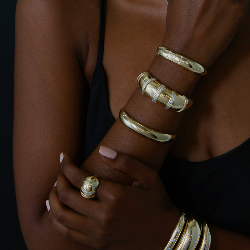 woman's arm crossed over chest wearing a Zoë Chicco 14k Gold Pavé Diamond Banded Large Aura Cuff Bracelet on her wrist