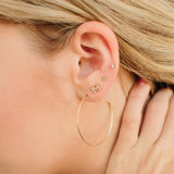 close up of woman's ear with Zoe Chicco 14kt gold and diamond earrings