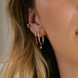 close up of woman wearing a Zoë Chicco 14k Gold Large Oval Hinge Hoop Earring with Dangling Diamond