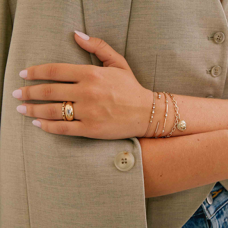 woman in beige suit jacket resting her hand on her arm wearing a Zoë Chicco 14k Gold Rectangle Link Ring stacked with an aura ring