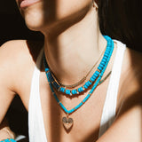 woman wearing a Zoë Chicco 14k Gold Large Radiant Heart Padlock Charm Pendant on a Turquoise Rondelle Bead Necklace