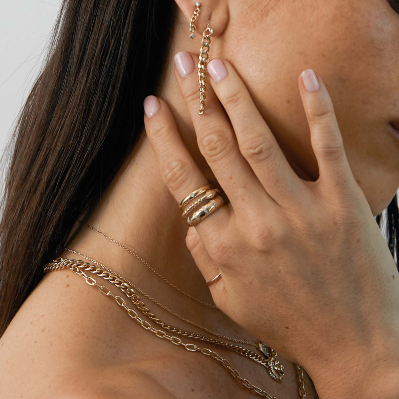woman with her hand resting on neck wearing a Zoë Chicco 14k Gold Beaded Diamond Snake Ring on her index finger