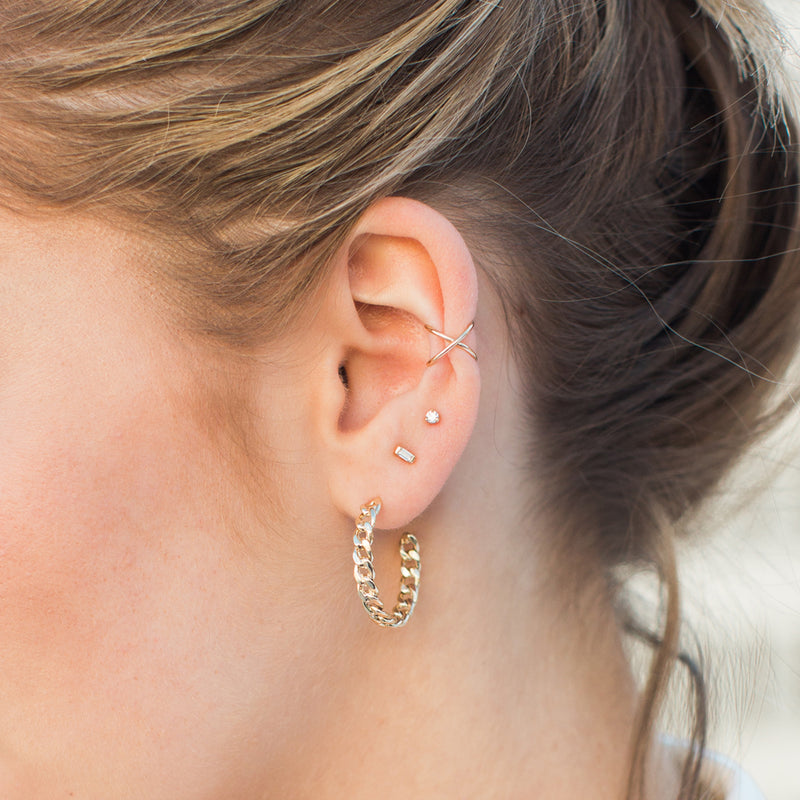 close up of woman's ear wearing a Zoë Chicco 14k Gold Small Baguette Diamond Stud Earring in her second piercing