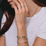 woman in white shirt wearing Zoë Chicco 14k Gold Pavé Diamond Border Large Curb Chain ID Bracelet on her wrist