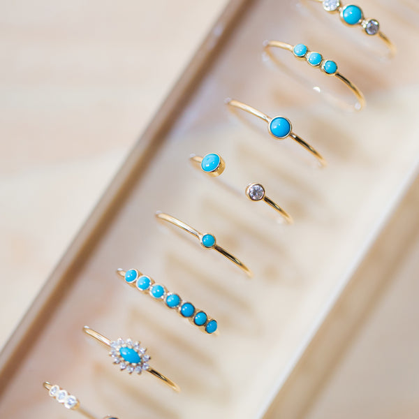 row of turquoise and diamond gold stacking rings