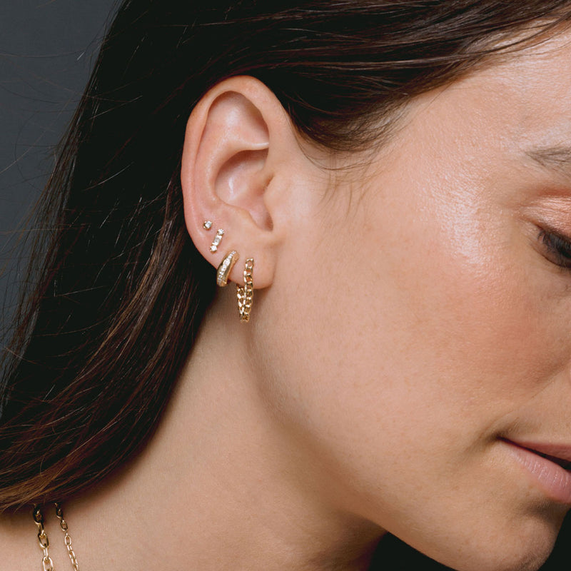 brunette woman's side profile wearing Zoë Chicco 14k Gold Baguette & 2 Prong Diamond Stud Earring in her ear