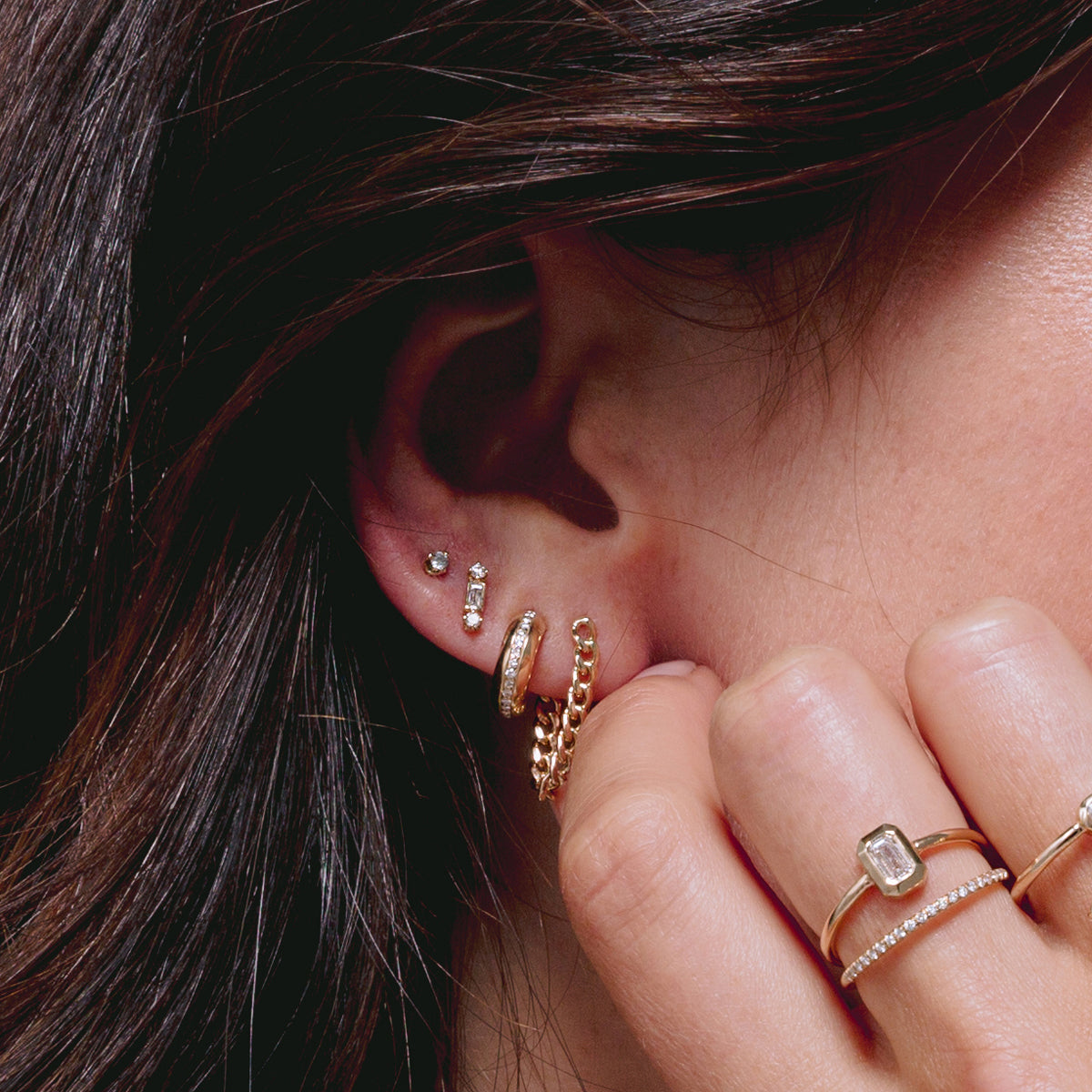close up of woman's ear wearing Zoë Chicco 14k Gold Small Curb Chain Huggie Earring