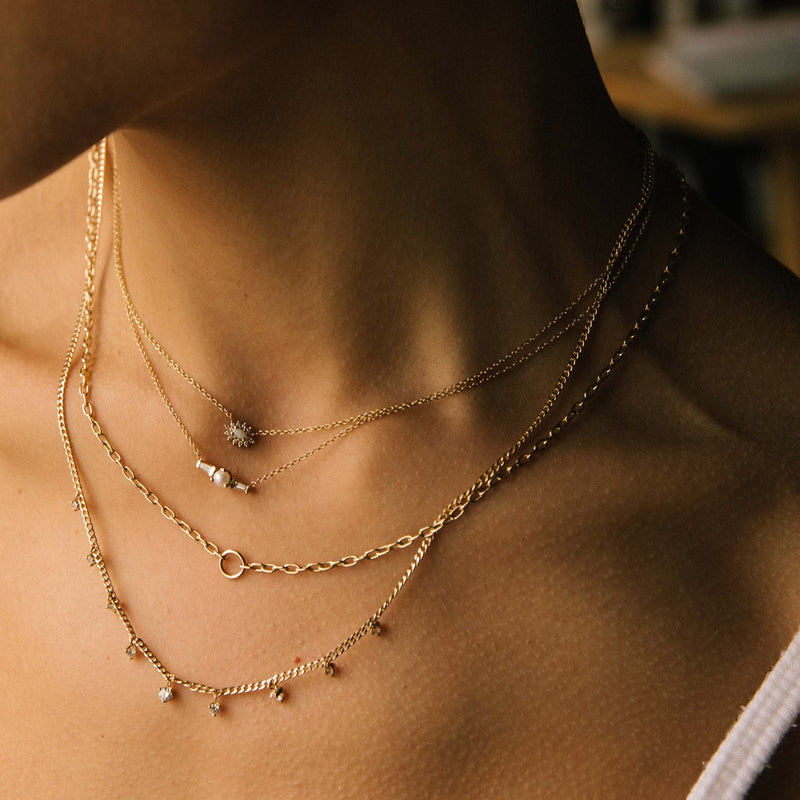 woman in white cami top wearing a Zoe Chicco 14k Gold Opal and Diamond Cluster Necklace layered with a Pearl & Tapered Baguette Diamonds Necklace, Circle Pendant Small Square Oval Link Chain Necklace, and a 9 Dangling Prong Diamond Extra Small Curb Chain Necklace