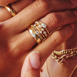 stack of gold and diamond rings on a woman's hand