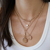 woman in white tank top wearing a Zoë Chicco 14k Gold Medium Square Oval Chain Necklace with Fob Clasp Drop with a Clip on Animal Hexagon Charm Pendant attached
