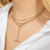 close up of woman in white top wearing Zoë Chicco 14kt Gold Small Curb Chain Floating Diamond Necklace layered with a Medium Rope Chain and a Square Oval Link Toggle Lariat Necklace