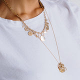 woman in white t-shirt wearing a Zoë Chicco 14kt Gold Medium Square Oval Link Chain Necklace with multiple spring ring charms attached onto the chain