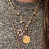 woman in grey shirt wearing a Zoë Chicco 14kt Gold Medium Square Oval Link Chain with Lobster Clasps with a Mantra with Diamond Border Charm Pendant dangling from the bottom
