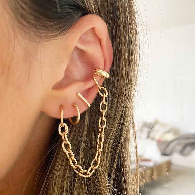 close up of woman's ear wearing Zoe Chicco 14kt Gold Single Diamond Thin Bar Stud Earrings