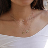 woman in white top wearing Zoe Chicco 14kt Gold Engraved Initial Halo Disc Necklace