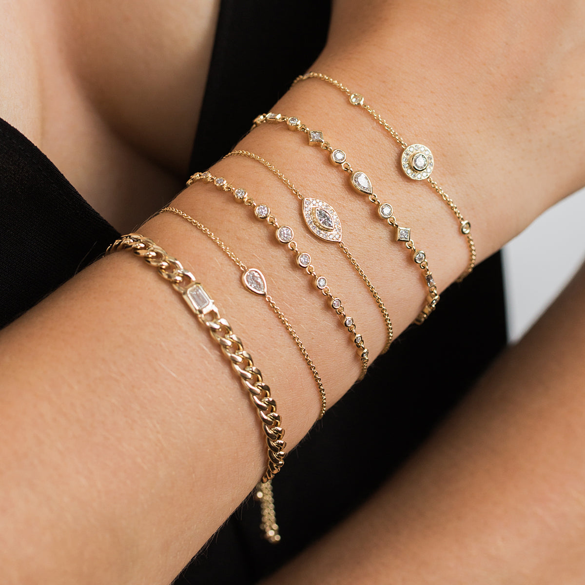 woman's wrist wearing Zoe Chicco 14kt Gold Large Mixed Diamond Linked Bolo Bracelet stacked with other bracelets