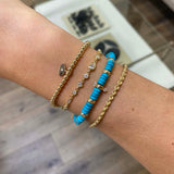 woman's wrist wearing a Zoë Chicco 14k Small Gold Bead Bracelet with Diamond Evil Eye