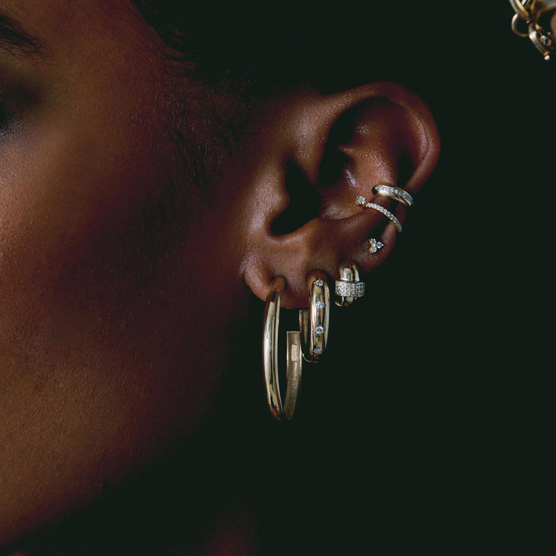 woman's ear wearing a Zoë Chicco 14k Gold Half Round Large Hoop Earring layered with other Heavy Metal earrings