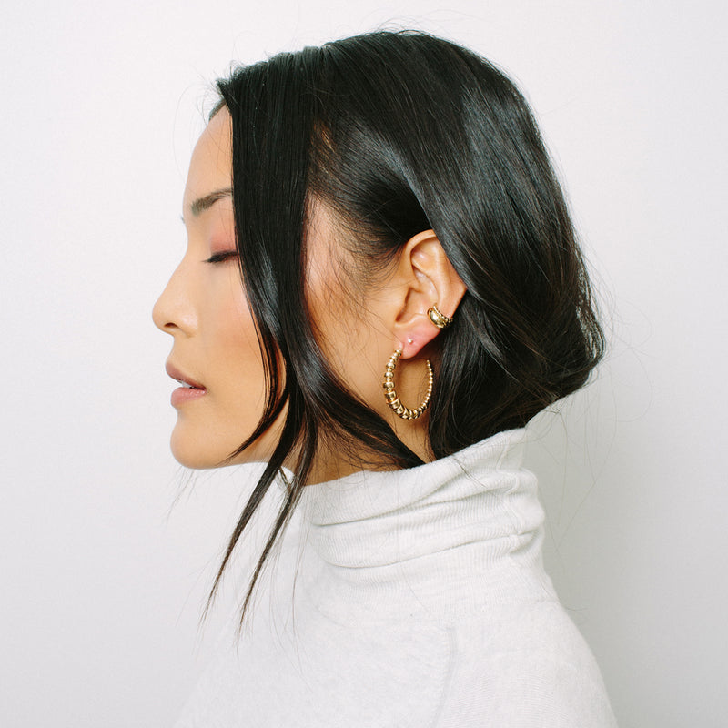 woman in white turtleneck turned to the side wearing Zoë Chicco 14kt Gold Graduated Rondelle Bead Medium Hoop Earring