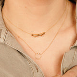 woman's neck wearing Zoë Chicco 14kt Gold Circle Prong White Diamond Necklace with a Gold Rondelle and Diamond Necklace
