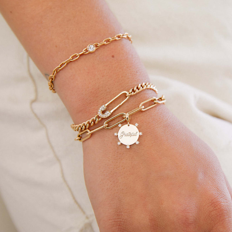 woman's wrist wearing a Zoë Chicco 14k Gold Pavé Diamond Safety Pin Medium Curb Chain Bracelet