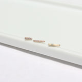 a Zoe Chicco 14k Gold Single Diamond Thin Bar Stud Earring laying with two pave diamond bar stud earrings in a row