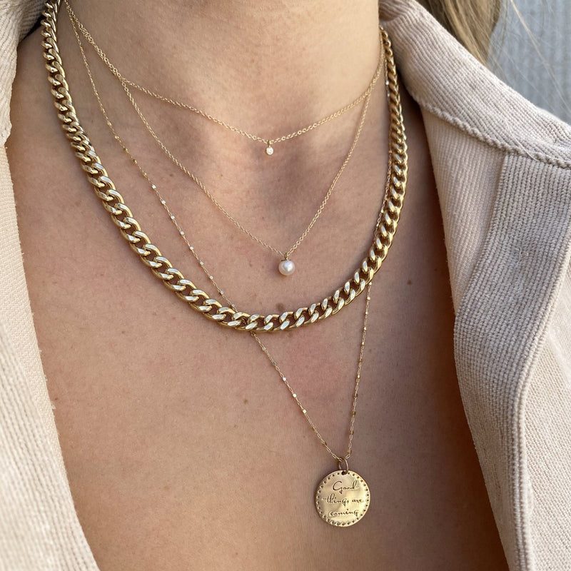 woman wearing Zoë Chicco 14kt Gold Diamond Bezel & Pearl Layered Chain Necklace layered with a Small Mantra long chain necklace and a Large Curb Chain necklace