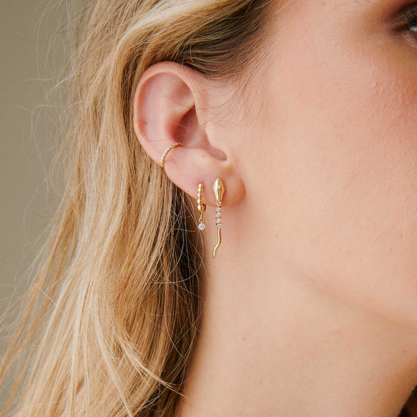 woman's ear wearing a Zoë Chicco 14k Gold Diamond Tennis Snake Drop Earring