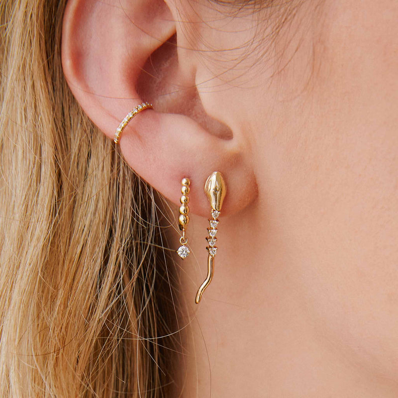 close up of woman's ear wearing a Zoë Chicco 14k Gold Diamond Tennis Snake Drop Earring