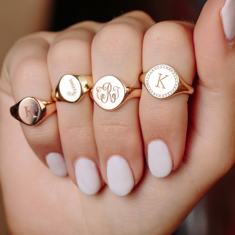 woman's closed hand with four Zoe Chicco 14kt Gold Signet Rings on different fingers