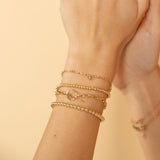 woman with her arm up wearing a Zoë Chicco 14k Gold Medium Square Oval Link Chain Toggle Bracelet