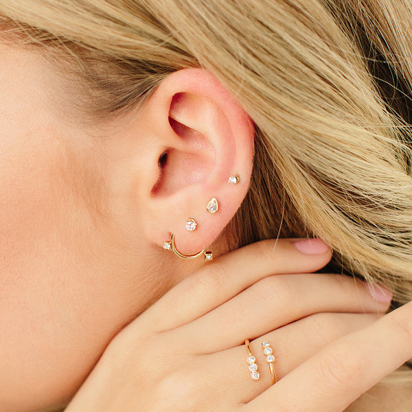 woman's ear wearing Zoë Chicco 14kt Gold Pear Diamond Bezel Stud Earrings