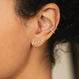 close up of woman's ear wearing a Zoe Chicco 14k Gold Plain Ear Cuff and Pavé Diamond Thick Ear Cuff with an Itty Bitty Pavé Diamond MAMA Stud Earring