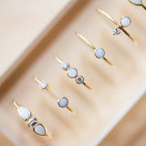 a row of opal and diamond rings