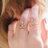 woman's hand wearing a Zoë Chicco 14k Gold 10 Tiny Diamond Bezel Bar Ring