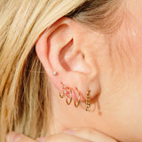 woman wearing a Zoë Chicco 14k Gold Thin Double Huggie Hoop Earrings in her second piercing