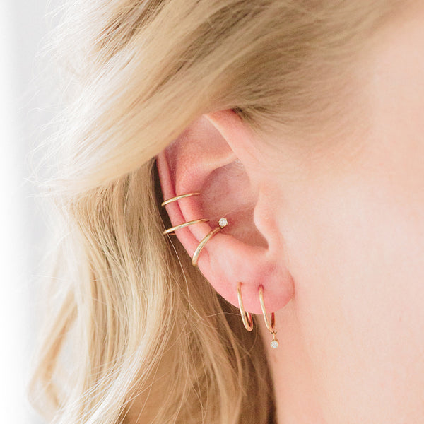 close up of woman's ear wearing a Zoë Chicco 14k Gold Dangling Diamond Thin Double Huggie Hoop Earring
