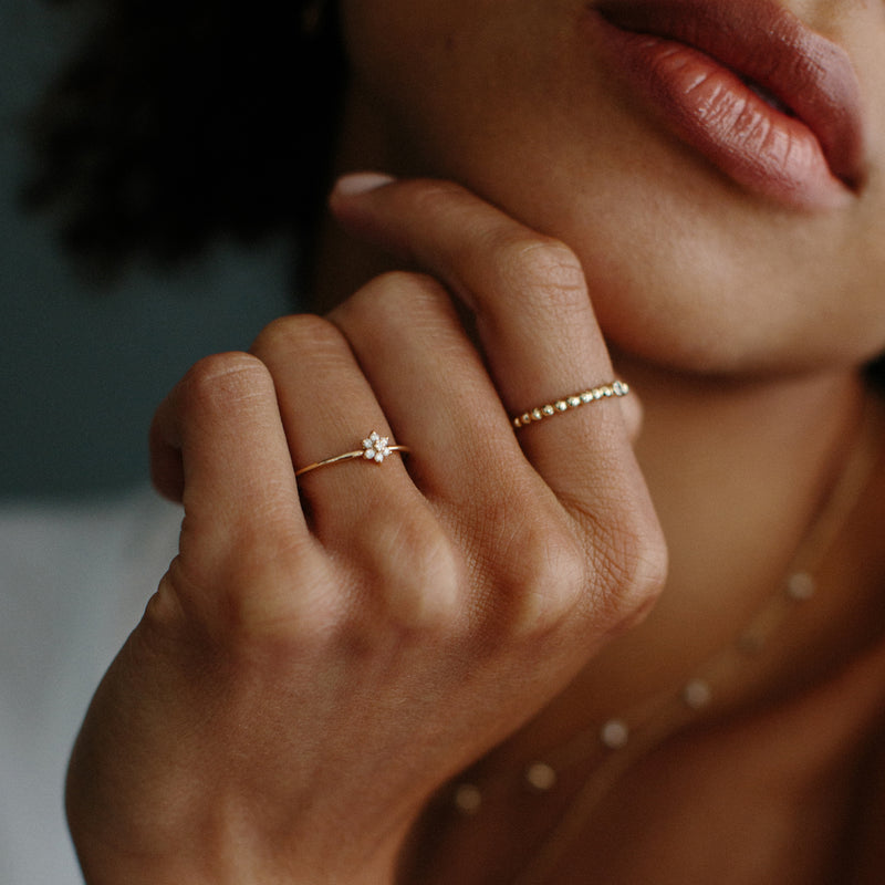woman wearing a Zoë Chicco 14k Gold Tiny Diamond Gold Bead Eternity Ring on her index finger
