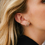 close up of woman's ear wearing a Zoë Chicco 14k Gold Vintage Pavé Diamond Horsebit Link Stud Earring layered with two other pave diamond earrings