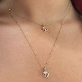 woman wearing Zoe Chicco 14kt Gold Pave Diamond Midi Bitty Zodiac Charms on chain necklaces