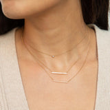 woman wearing a Zoë Chicco 14k Yellow Gold Classic Round Diamond Bezel Necklace layered with two bar necklaces