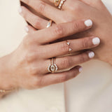 a woman's hand wearing a Zoë Chicco 14k Gold Graduated Prong Diamond Curved Bar Ring stacked with a one of a kind Oval Rose Cut Diamond Ring and a Graduated Diamond Bezel Ring on her ring finger and a Prong Diamond Trio Open Ring on her middle finger