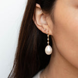 brunette woman wearing a Zoë Chicco 14k Gold Linked Prong Diamond & Baroque Pearl Drop Earring 