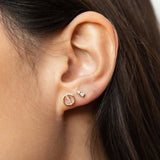 woman's ear wearing a Zoë Chicco 14k Gold Pavé Diamond Line Circle Stud Earring with a  2 Mixed Size Prong Diamond Stud