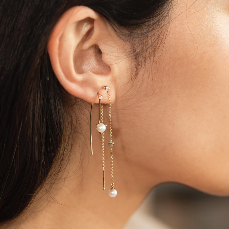 woman's ear wearing a Zoë Chicco 14k Gold Floating Diamond & Pearl Chain Threader Earring layered with a 14k Pearl & Diamond Wire Threader in the second piercing