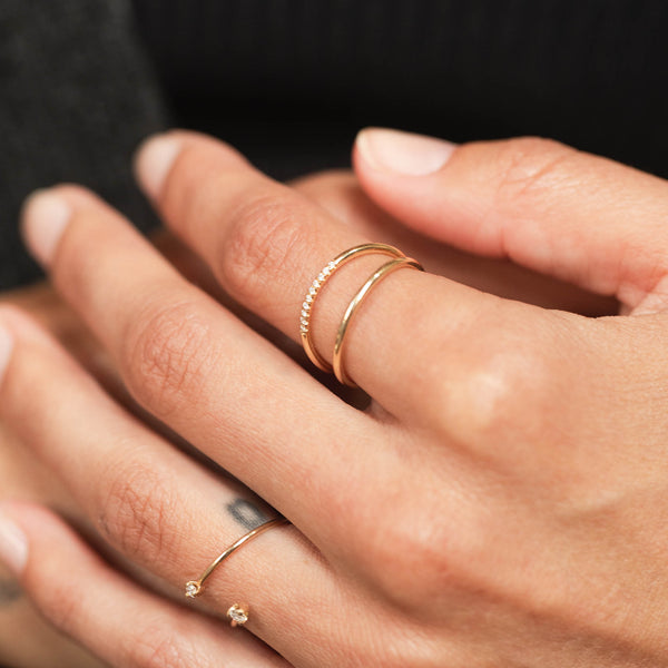 close up of woman's hand wearing a Zoë Chicco 14k Gold 10 Pavé Diamond Split Double Band Ring on her index finger