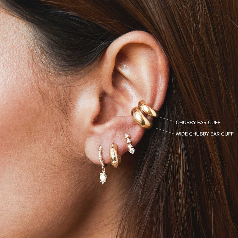 close up of a woman's ear wearing a Zoë Chicco 14k Gold Wide Half Round Chubby Ear Cuff 