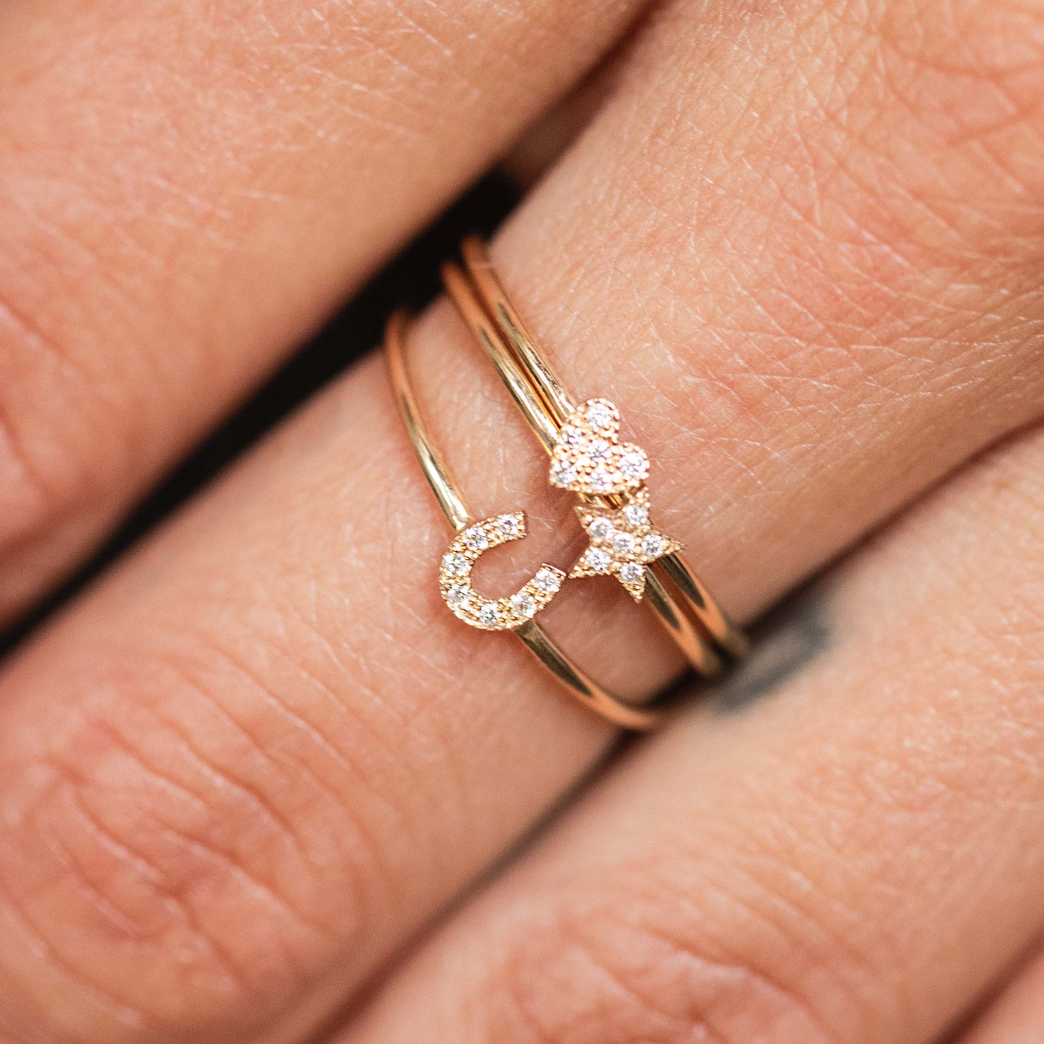 woman's finger wearing a Zoë Chicco 14k Gold Itty Bitty Pavé Diamond Star Ring layered with two other itty bitty pave diamond rings